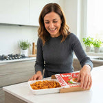 Box X1 settimana piatti pronti: donna felice apre il pacco con pasta rotini pronta per gustare.