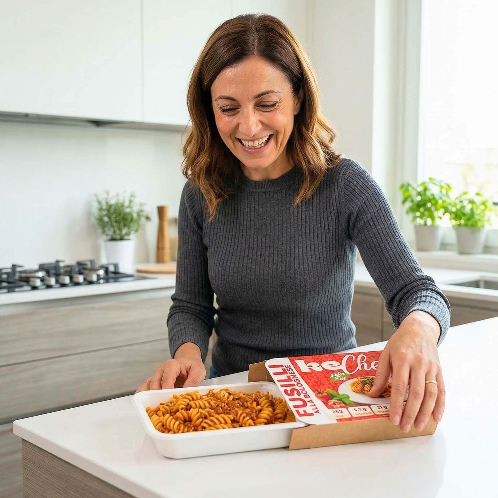 Box X1 settimana piatti pronti: donna felice apre il pacco con pasta rotini pronta per gustare.