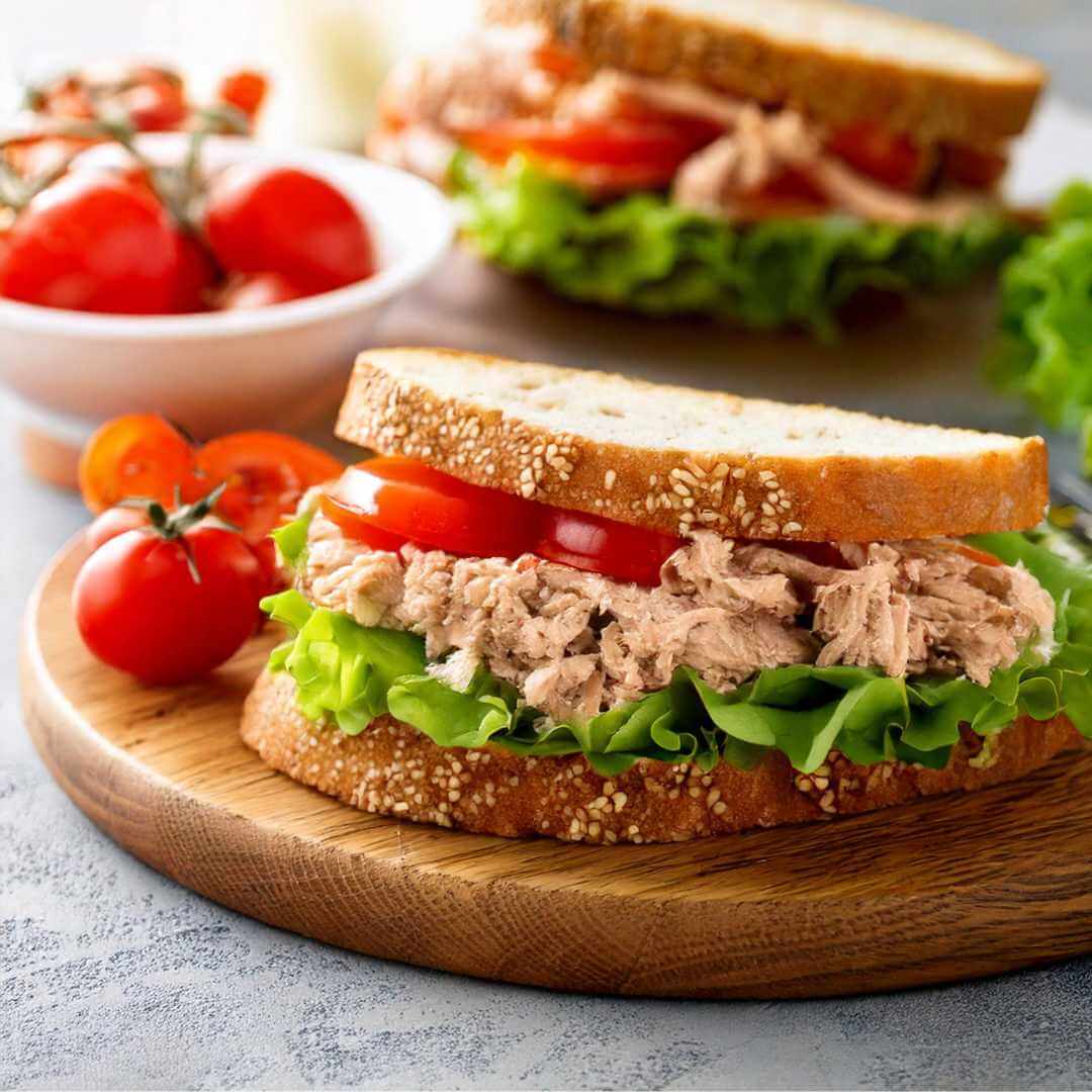Sandwich di pane proteico con tonno, pomodori e lattuga, ideale per dieta chetogenica e alimenti keto.