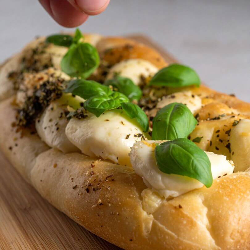 Pinsa proteica con basilico fresco e mozzarella, ideale per dieta chetogenica e alimenti proteici.