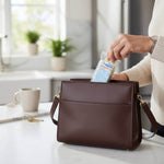 Una donna inserisce un pacchetto in una borsa marrone su un tavolo di cucina.