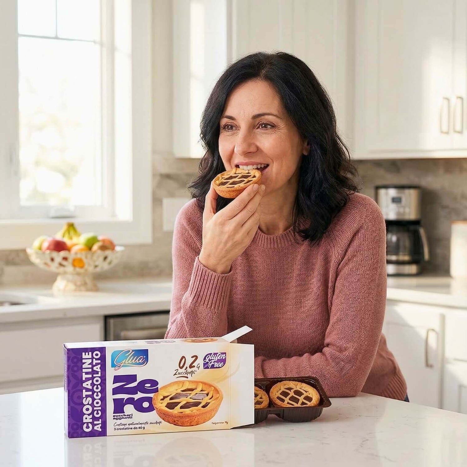 Una donna sorride mentre gusta le Crostatine con crema al cioccolato, ottime per dieta chetogenica.