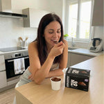 Kebudino proteico al cioccolato: donna gusta un delizioso budino al cioccolato in cucina, dieta chetogenica.